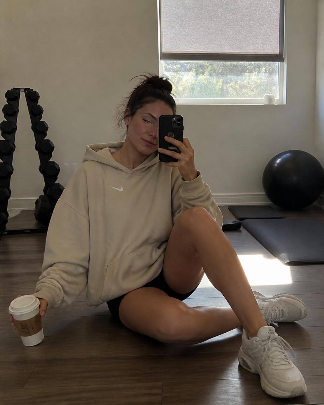 Sandfärgad hoodie och svarta shorts på studiogolv